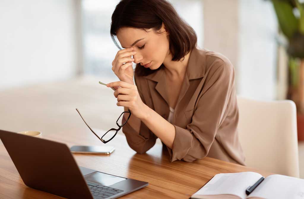 62510200_exhausted-manager-girl-massaging-nose-and-using-laptop